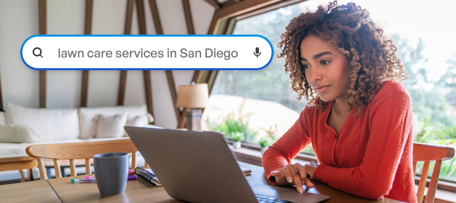A woman searching "lawn care services in San Diego" on her laptop