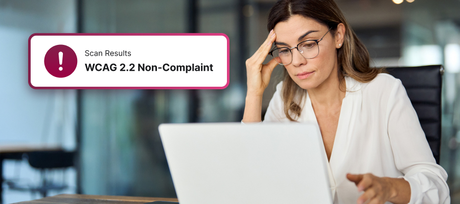 A stressed woman looking at her laptop with a WCAG 2.2 non-compliant issue