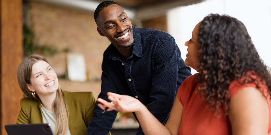 A happy man talking to two happy women