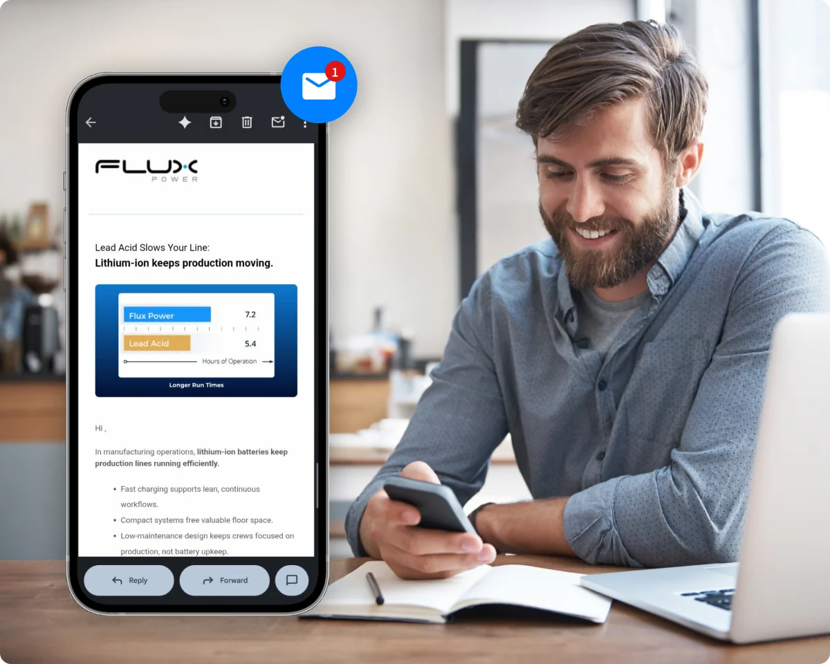 Man reading a branded Flux Power marketing email on his phone while working at a cafe.
